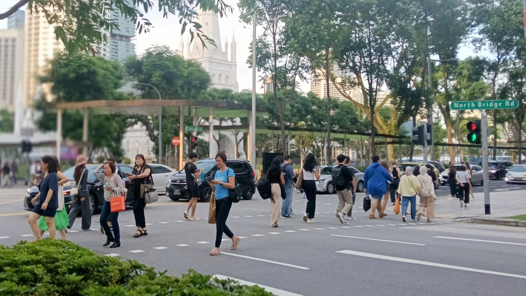 A group of people crossing the street at North Bridge Road in Singapore