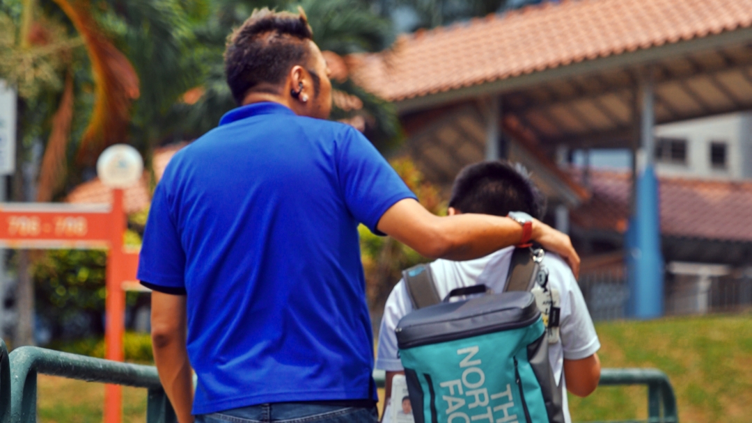 Full-time ComfortDelGro taxi driver Ricky Low (left) fetches his son from school every day.