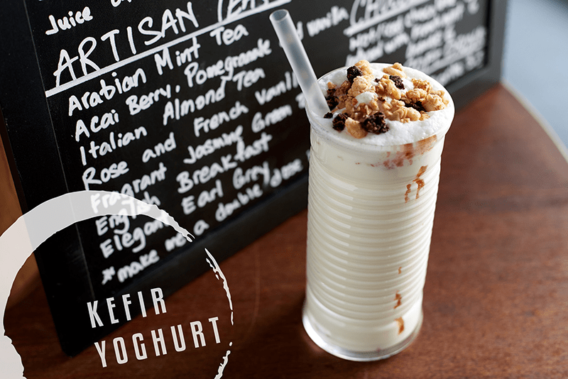 A glass of Kefir Yogurt with a menu in the background