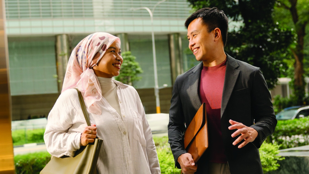 A middle-aged Asian man and woman walking down a pathway.