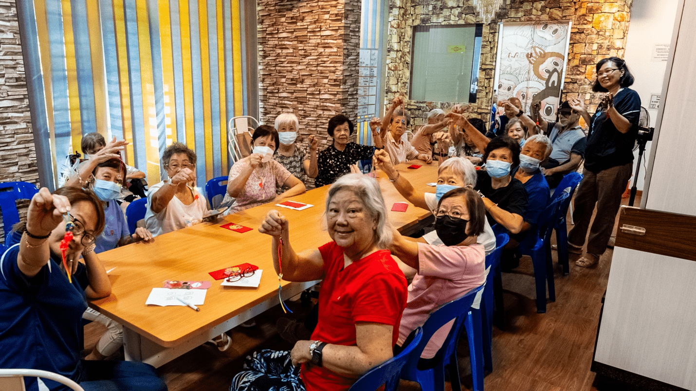 A group of seniors happily holding up their Chinese Knots with after a session with Ai Geok