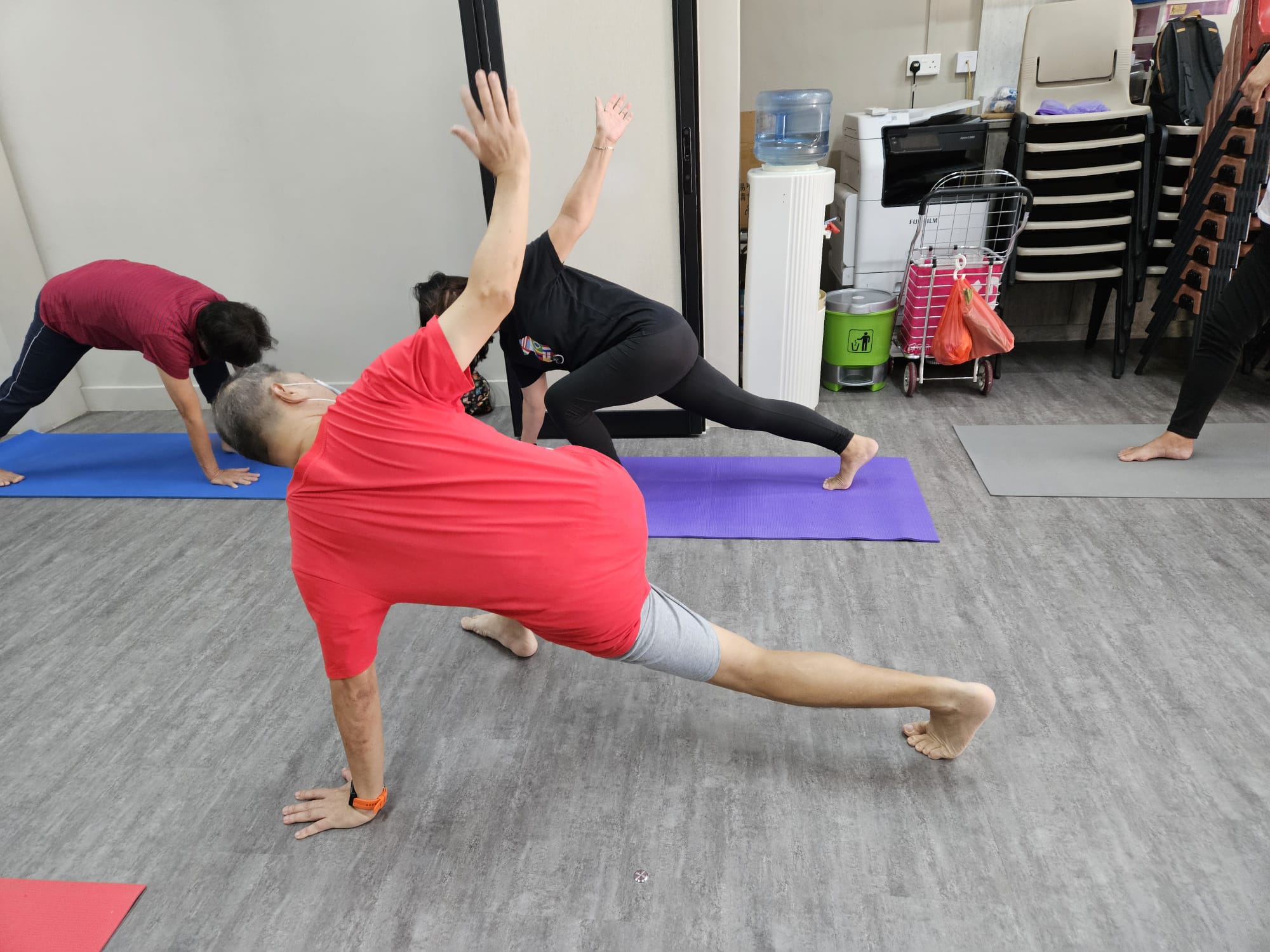 Lim Kim Huat guiding a stretching exercise